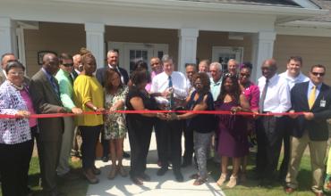a ribbon cutting ceremony on a front porch