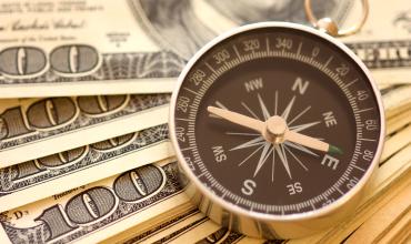 How to Prioritize Your Finances a compass on top of money