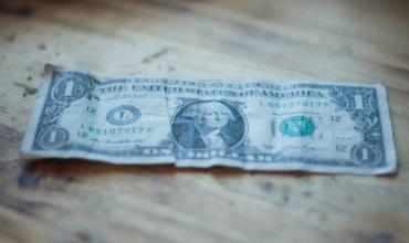 a dollar bill on a wooden table