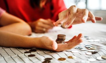 People stacking coins on a table