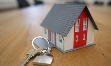 A toy house on a table with keys