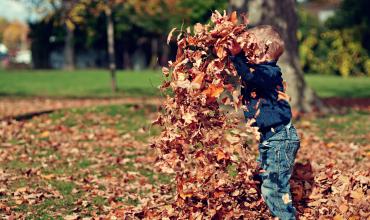 Home Buyer Mistakes and How to Avoid Them A child throwing a pile of fall leaves