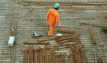 A man in an orange suit walking a construction site