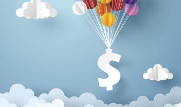 A dollar sign floating with multicolored balloons