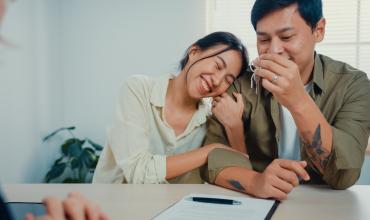 A happy couple sitting at a desk