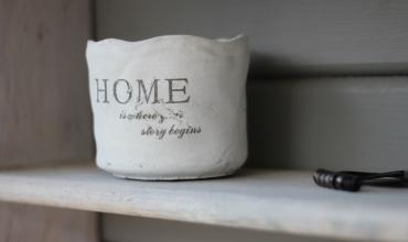 A coffee cup that says home on it