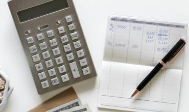 a calculator and checkbook on a table