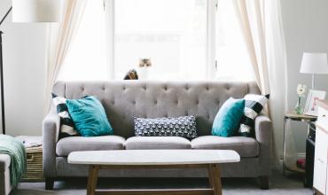 a gray couch with turquoise pillows 