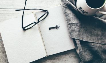 glasses sitting on top of a notebook with a key