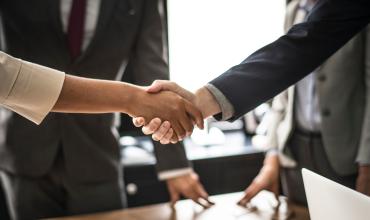 Community Home Ownership Programs Spark Investment, Boost Local Economies two business people shaking hands