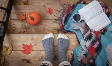 A fall scene with socks and a pumpkin with leaves