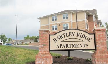 Photo of Hartley Ridge Apartments sign with building in the background