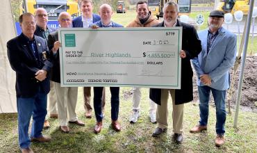 People holding up a big check
