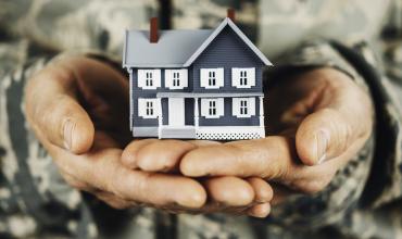 veteran holding a toy house