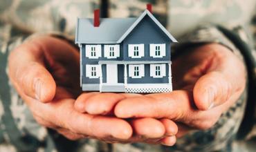 A veteran holding a house