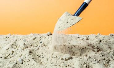 Groundbreaking Event for Abbott Crossing on September 11 in Goldsboro Shovel picking up dirt with a yellow background