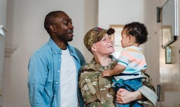 A man with his military wife holding their child