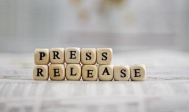 Scrabble letters spelling out "press release"