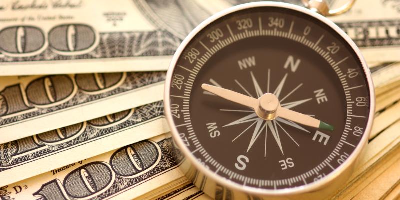 a compass on top of money