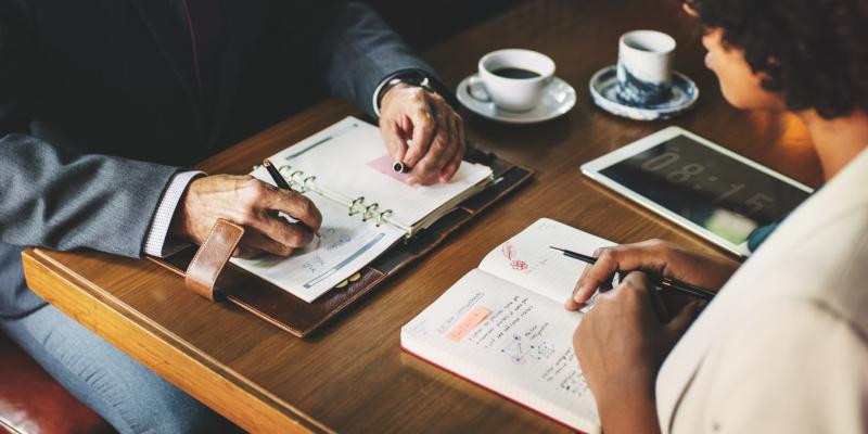 two people sitting at a desk doing finance work