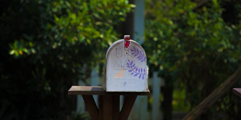 a mailbox with greenery around it