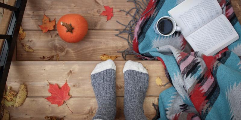 A fall scene with socks and a pumpkin with leaves