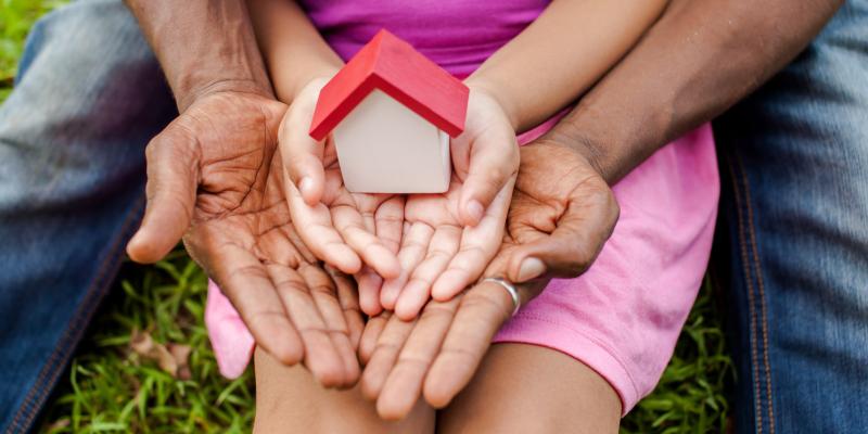 https://www.nchfa.com/news/policy-matters-blog/federal-reserve%E2%80%99s-home-ownership-affordability-monitor-helps-translate-north-carolina-housing-trends A dad and his daughter holding a mini house on their lawn