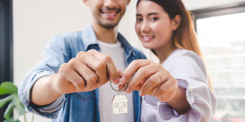 Couple holding up a key to their new home