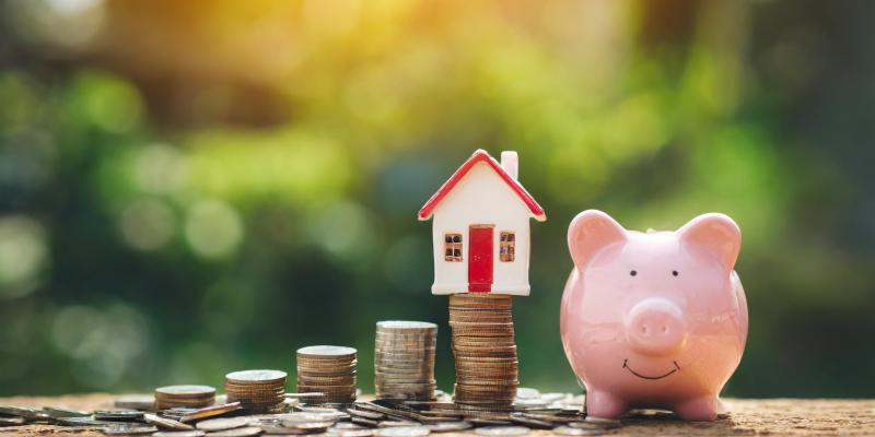 Should I Refinance My Mortgage? Learn the Basics First Coins stacked up with a house on top of them and a piggy bank to the right