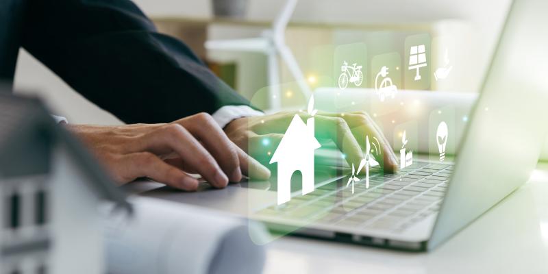 Severe Housing Affordability Challenges Worsen for Many North Carolinians A person sitting on this computer with fictional houses coming out of the computer