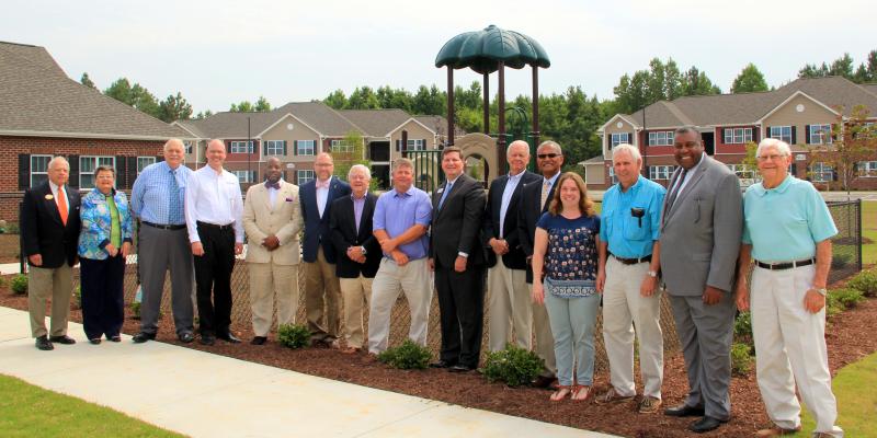 a group of people standing outside Enfield Commons apartments