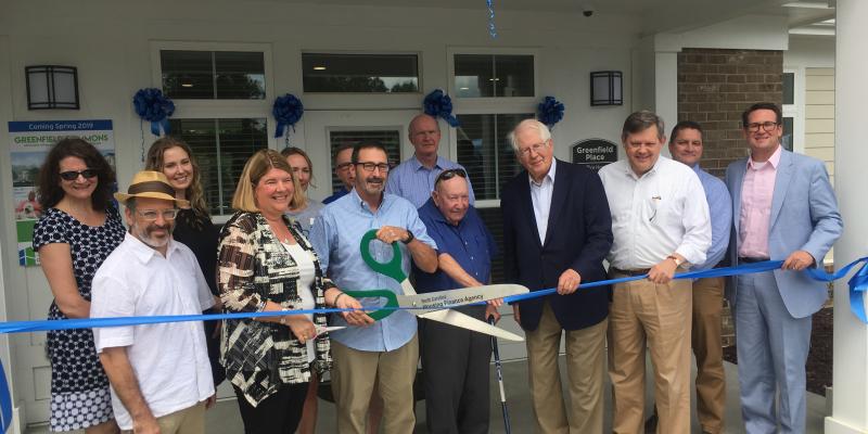 a ribbon cutting event at greenfield place apartments