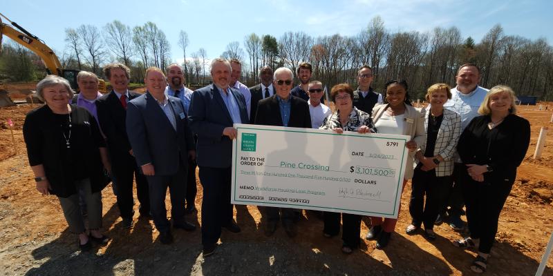 Group of people holding up a large check