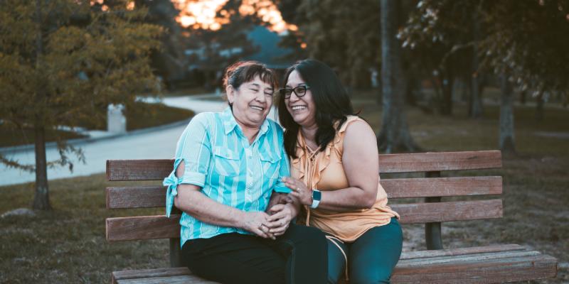 NCCARE360 Seeks Partners to Improve Health Statewide Two women laughing while sitting on a bench
