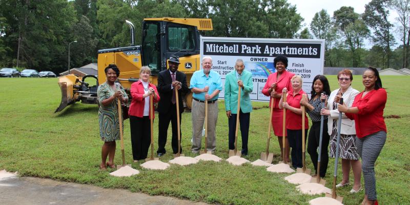 people holding shovels at a groundbreaking ceremony