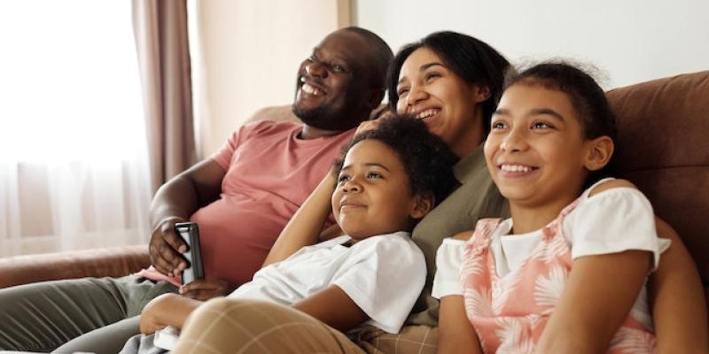 Four New Year’s Resolutions to Help You Buy a Home in 2023 A family sitting on the couch together