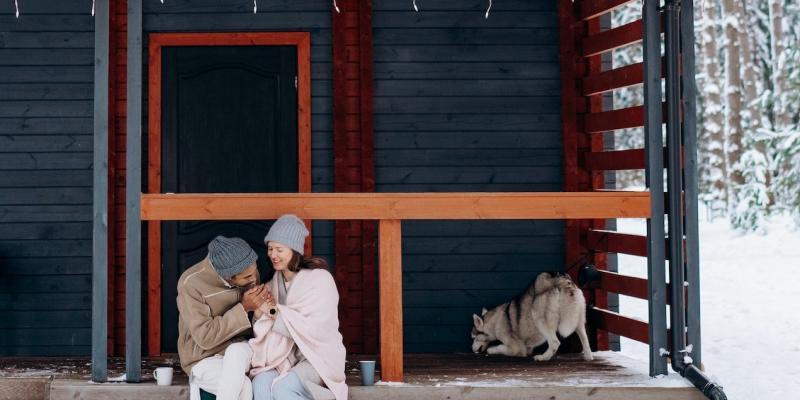 Couple hanging out on their front porch with their dog in the winter